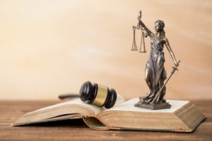 gavel and statue of justice on top of law book