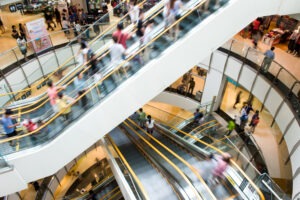 people on motion escalators modern shopping mall