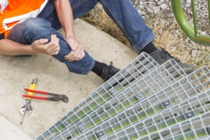 man with injured leg sitting on ground