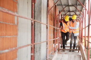 Two construction workers after an accident. If you sustained injuries on the job, you can work with a Long Beach construction accident lawyer. 