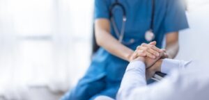 Female nurse holds her senior patient's hand. Call an Orange personal injury lawyer today.